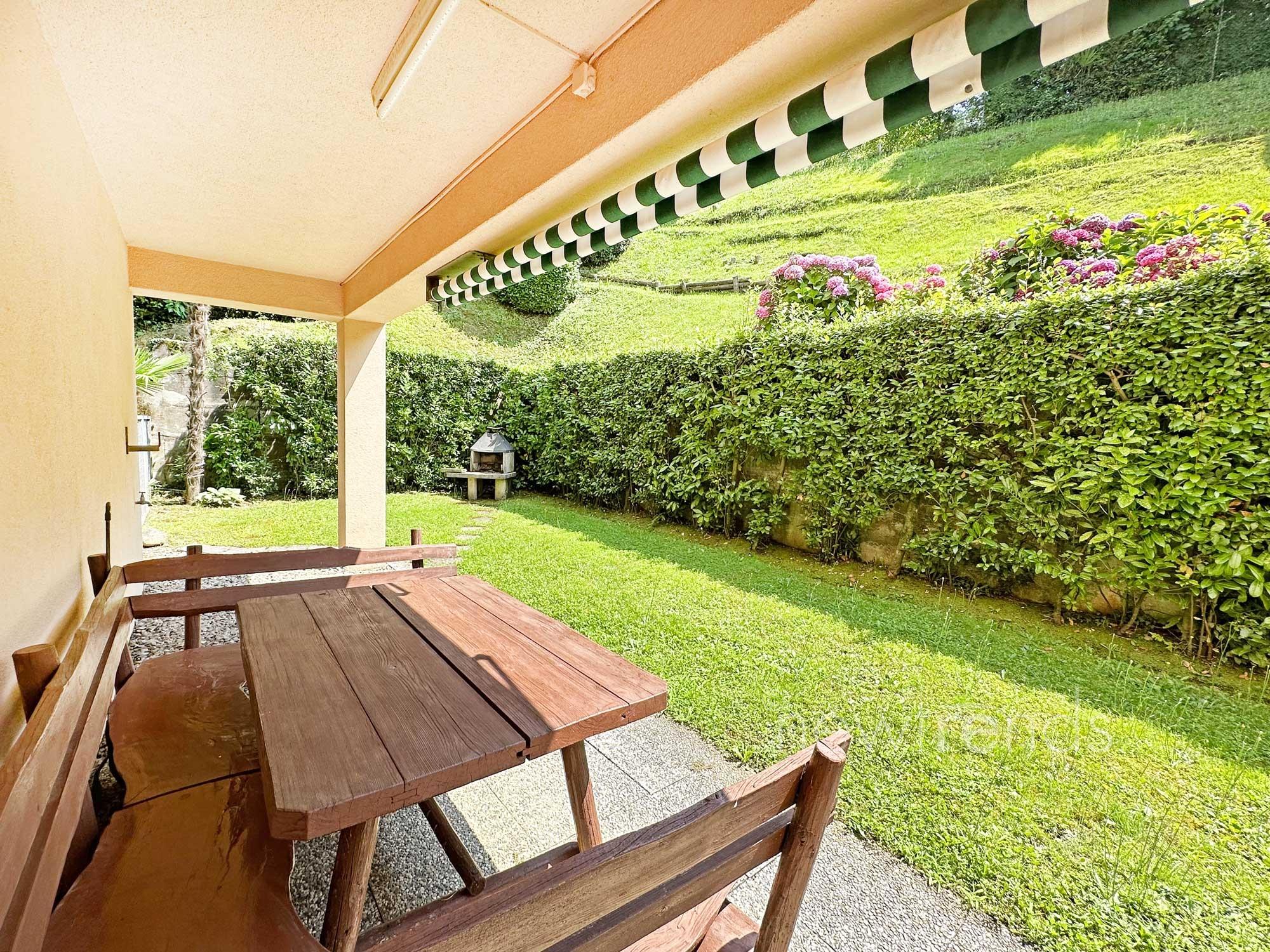 affittasi appartamento 3.5 locali con vista nel verde e scorcio di lago a pazzallo: foto giardino condominiale con area barbecue